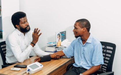 A medical professional consults with a patient during a blood pressure checkup in Lagos, Nigeria.