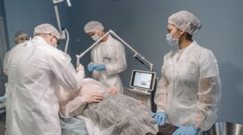 Healthcare professionals conducting a laser surgical procedure in a clinic setting.
