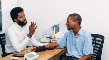 A medical professional consults with a patient during a blood pressure checkup in Lagos, Nigeria.